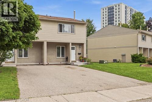 Two-story residence featuring light-colored siding, a paved driveway, and established landscaping - 15 Green Valley Drive Unit# 41, Kitchener, ON - Outdoor With Facade