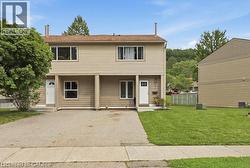 Duplex exterior with light-colored siding and white trim - 