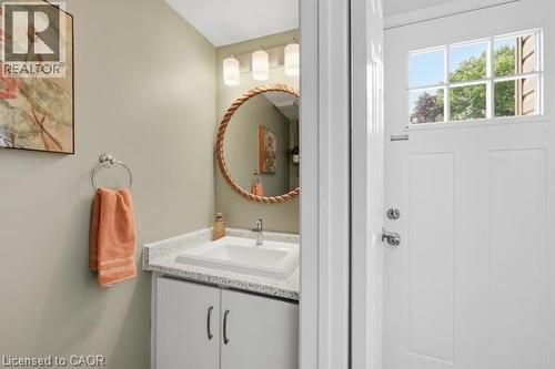 White paneled door with bathroom vanity with integrated sink, patterned countertop, and dual-door cabinetry - 15 Green Valley Drive Unit# 41, Kitchener, ON - Indoor Photo Showing Bathroom
