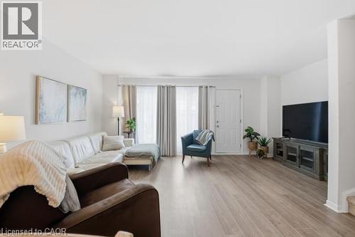 Expansive living space featuring wood-finish flooring and a white entry door - 15 Green Valley Drive Unit# 41, Kitchener, ON - Indoor Photo Showing Living Room