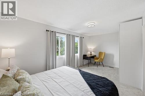 Textured ceiling with a flush-mount light fixture, light gray walls, and light gray carpeting - 15 Green Valley Drive Unit# 41, Kitchener, ON - Indoor Photo Showing Bedroom