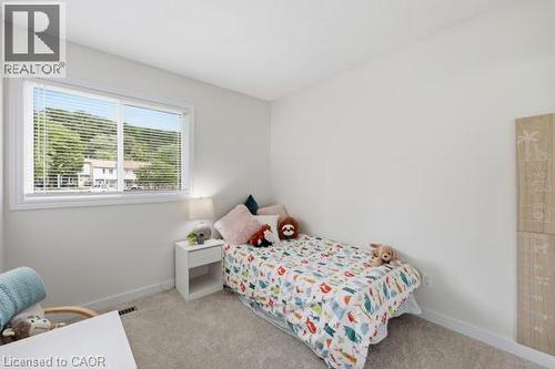 Bright room featuring a large window with white blinds, light-toned walls, and grey carpeting - 15 Green Valley Drive Unit# 41, Kitchener, ON - Indoor Photo Showing Bedroom