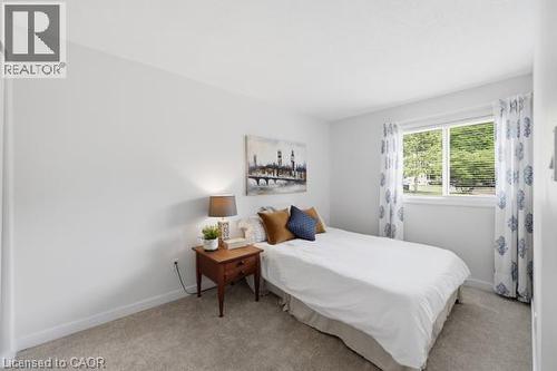 Neutral wall paint, carpet flooring, a window with blinds, and white trim - 15 Green Valley Drive Unit# 41, Kitchener, ON - Indoor Photo Showing Bedroom