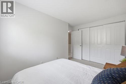 Wall-to-wall carpeting, white bi-fold closet doors, and light neutral wall paint - 15 Green Valley Drive Unit# 41, Kitchener, ON - Indoor Photo Showing Bedroom