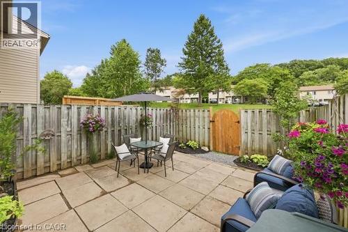 Paver patio with a wood privacy fence, decorative wood gate, and landscaped planting areas - 15 Green Valley Drive Unit# 41, Kitchener, ON - Outdoor With Deck Patio Veranda