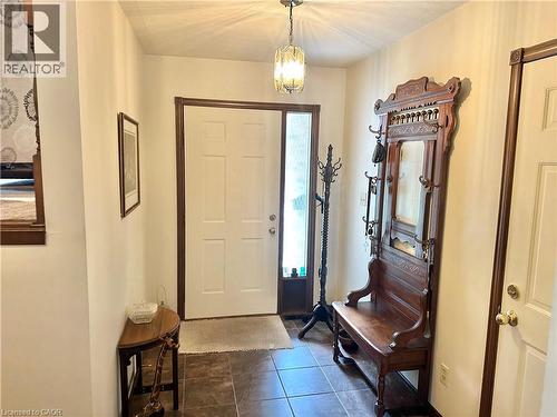 Tiled entryway with a paneled white door, a sidelight, and a decorative overhead light fixture - 44 Douglas Avenue, Simcoe, ON - Indoor Photo Showing Other Room