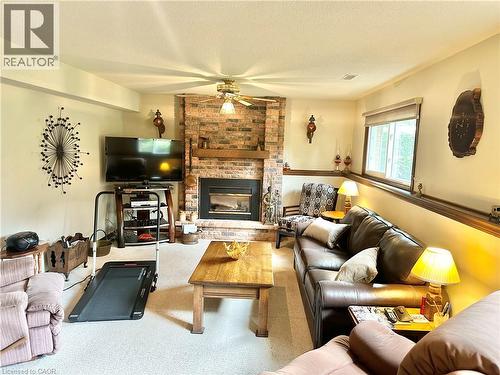 Brick-surround fireplace with a wood mantle, ceiling fan, carpeted flooring, - 44 Douglas Avenue, Simcoe, ON - Indoor Photo Showing Living Room With Fireplace