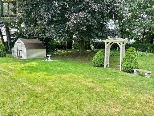 Expansive backyard featuring a storage shed, landscaped arbor, and mature trees - 44 Douglas Avenue, Simcoe, ON - Outdoor