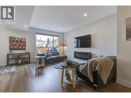 Wall-mounted TV setup keeps cords concealed for a clean, streamlined look - 747 Patterson Avenue Unit# 2, Kelowna, BC - Indoor Photo Showing Living Room With Fireplace