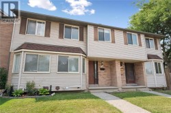 Two-story exterior with light-toned siding, dark brown shutters, and a bay window - 