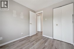 Light gray walls with wood-finish flooring, white trim, and a white bi-fold closet door - 