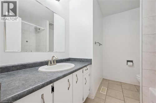 Vanity with an integrated sink, brushed nickel faucet, large wall mirror, and white cabinetry - 750 Erinbrook Drive Unit# 2, Kitchener, ON - Indoor Photo Showing Bathroom