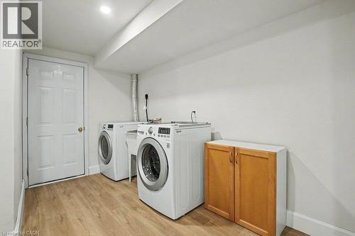 Laundry area featuring wood-finish flooring and ready to mount wood cabinetry - 568 Robert Ferrie Drive, Kitchener, ON - Indoor Photo Showing Laundry Room