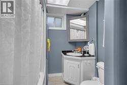 Corner vanity with a built-in sink, dark countertop, and white cabinetry - 