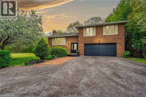 Brick exterior with an attached two-car garage, large windows, and mature landscaping - 152 Concession 7 Road E, Millgrove, ON - Outdoor