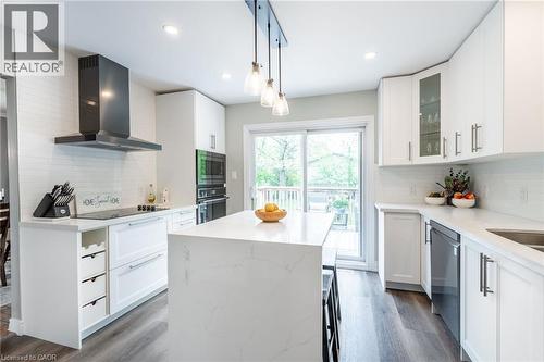 White shaker-style cabinetry, a contrasting dark range hood, a kitchen island with a white countertop, stainless steel appliances, and a glass sliding door - 152 Concession 7 Road E, Millgrove, ON - Indoor Photo Showing Kitchen With Upgraded Kitchen