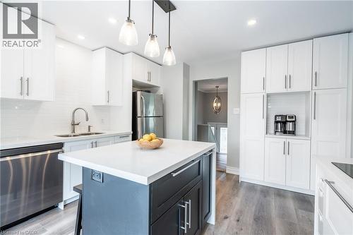 White shaker cabinetry, stainless steel appliances, white subway tile backsplash, white countertop surfaces, and a two-tone kitchen island - 152 Concession 7 Road E, Millgrove, ON - Indoor Photo Showing Kitchen With Double Sink With Upgraded Kitchen