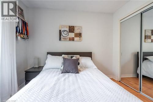 Sliding mirrored closet doors, wood-finish flooring, and a built-in dark wood headboard - 152 Concession 7 Road E, Millgrove, ON - Indoor Photo Showing Bedroom