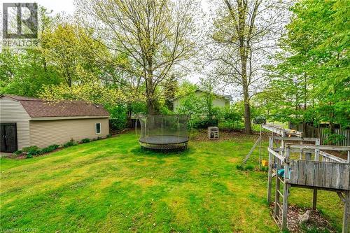 Expansive green lawn with mature trees and a detached shed featuring tan siding and a shingle roof - 152 Concession 7 Road E, Millgrove, ON - Outdoor With Backyard