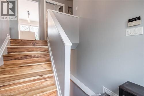 Natural wood-finish staircase with white risers and handrail, complemented by a gray wall and white trim - 152 Concession 7 Road E, Millgrove, ON - Indoor Photo Showing Other Room