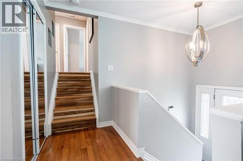 Hardwood flooring, wood-finish stairs, mirrored closet doors, contemporary chandelier, and decorative glass entry door - 152 Concession 7 Road E, Millgrove, ON - Indoor Photo Showing Other Room