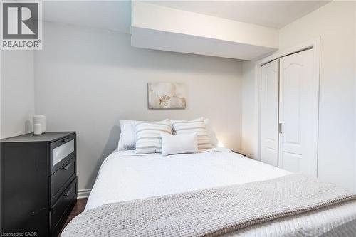 White painted walls, wood-finish flooring, and white bi-fold closet doors - 152 Concession 7 Road E, Millgrove, ON - Indoor Photo Showing Bedroom