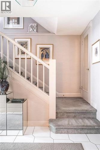 Staircase featuring white balusters and a carpeted tread - 107 Bond Street S, Hamilton, ON - Indoor Photo Showing Other Room