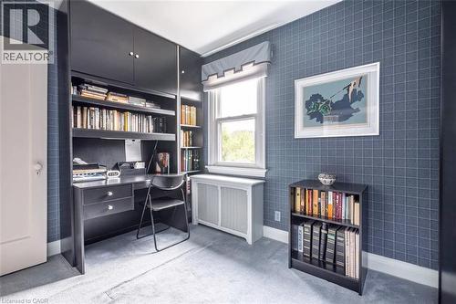 Built-in desk with integrated shelving and overhead cabinetry - 107 Bond Street S, Hamilton, ON - Indoor Photo Showing Office
