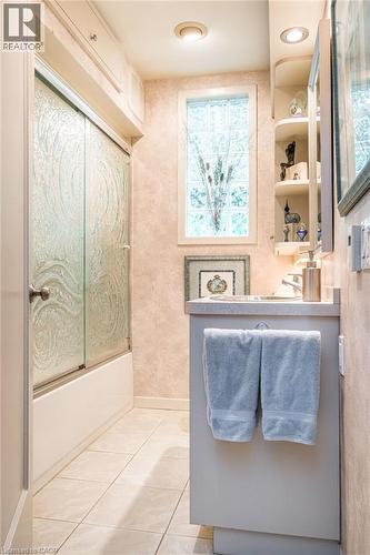 Recessed lighting, glass block window, built-in medicine cabinet, single vanity with countertop, and ceramic tile flooring - 107 Bond Street S, Hamilton, ON - Indoor Photo Showing Bathroom