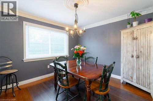 Dining area featuring wood-finish flooring, a large window and crown molding - 111 Decou Road, Simcoe, ON - Indoor Photo Showing Dining Room