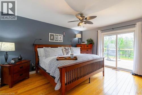 Spacious room featuring hardwood flooring, a ceiling fan with integrated lighting, and a sliding glass door providing access to an exterior deck - 111 Decou Road, Simcoe, ON - Indoor Photo Showing Bedroom
