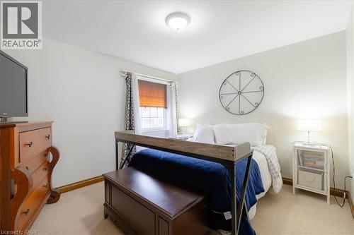 Carpeted room with a ceiling-mounted light fixture, a window with blinds and curtains, and light-colored walls - 111 Decou Road, Simcoe, ON - Indoor Photo Showing Bedroom