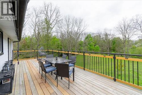 Expansive wood-finish deck with black metal and wood railing - 111 Decou Road, Simcoe, ON - Outdoor With Deck Patio Veranda