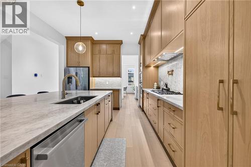 Modern kitchen featuring wood-finish cabinetry, light-toned countertops, and light wood-finish flooring - 67 Cielo Court, Hamilton, ON - Indoor Photo Showing Kitchen With Upgraded Kitchen