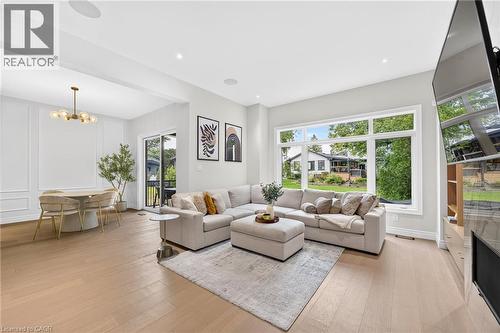 Recessed lighting, wood-finish flooring, large picture window, glass sliding door, and wall paneling - 67 Cielo Court, Hamilton, ON - Indoor Photo Showing Living Room
