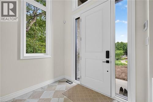 White paneled entry door with matte black hardware, sidelight, and transom window - 67 Cielo Court, Hamilton, ON - Indoor Photo Showing Other Room