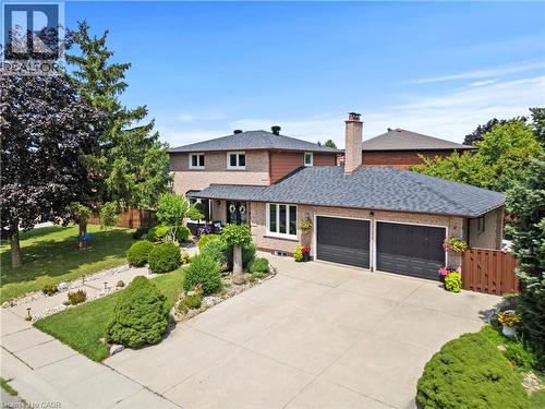 Brick exterior residence featuring an attached two-car garage, concrete driveway, and a shingled roof - 87 Monte Drive, Hamilton, ON - Outdoor