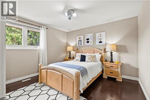 Dark wood-finish flooring, light neutral wall color, and white trim - 87 Monte Drive, Hamilton, ON - Indoor Photo Showing Bedroom