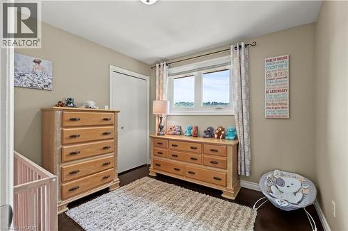 Double-pane window with white trim, dark wood-finish flooring, and a white bi-fold closet door - 87 Monte Drive, Hamilton, ON - Indoor Photo Showing Other Room