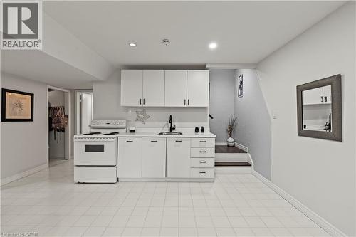 White cabinetry with dark hardware, white countertop, and a white electric range - 87 Monte Drive, Hamilton, ON - Indoor Photo Showing Kitchen