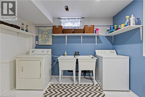 Laundry area featuring a double utility sink, washer, dryer, and wall-mounted shelving - 87 Monte Drive, Hamilton, ON - Indoor Photo Showing Laundry Room