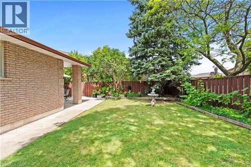 Expansive backyard featuring a manicured lawn, established perimeter landscaping, and a privacy fence - 87 Monte Drive, Hamilton, ON - Outdoor