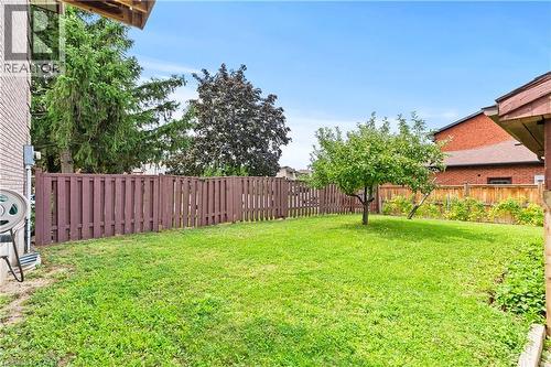 Expansive backyard featuring a green lawn, wood privacy fencing, and mature trees - 87 Monte Drive, Hamilton, ON - Outdoor