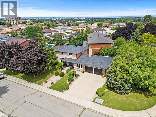 Brick and stone exterior with modern architectural detailing, set on a landscaped lot featuring mature trees and manicured lawn - 87 Monte Drive, Hamilton, ON - Outdoor With View