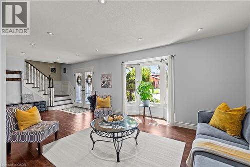 Recessed lighting, wood-finish flooring, white double entry doors, bay window, and a staircase with white balusters - 87 Monte Drive, Hamilton, ON - Indoor Photo Showing Living Room