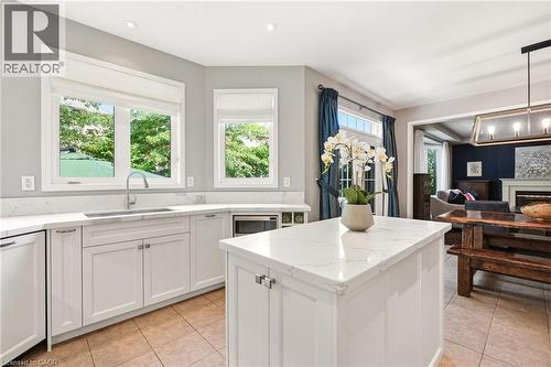 Bright, chef-inspired kitchen featuring white shaker cabinetry, white quartz countertops, and a substantial center island with prep space - 536 Cusick Circle, Milton, ON - Indoor Photo Showing Kitchen With Fireplace