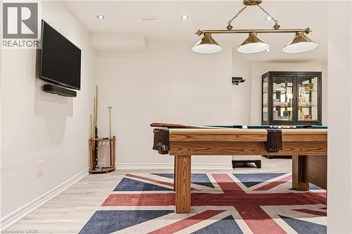 Recreation room featuring a wood-finish pool table, plank flooring with Union Jack-pattern area rug, wall-mounted flat-screen television, brass three-light pendant fixture, and built-in cabinetry with - 536 Cusick Circle, Milton, ON - Indoor Photo Showing Other Room