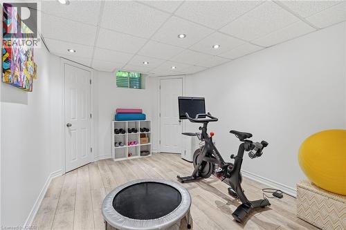 Recessed lighting, wood-finish flooring, white paneled doors, and a drop ceiling - 536 Cusick Circle, Milton, ON - Indoor Photo Showing Gym Room