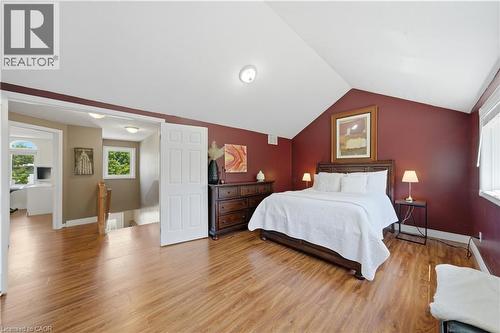 Spacious room featuring wood-finish flooring, a vaulted ceiling, and burgundy painted walls - 784 Butternut Avenue, Waterloo, ON - Indoor Photo Showing Bedroom