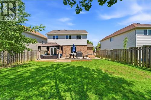 Spacious backyard featuring a wooden privacy fence, a large deck, and a built-in hot tub with a gazebo - 784 Butternut Avenue, Waterloo, ON - Outdoor With Deck Patio Veranda